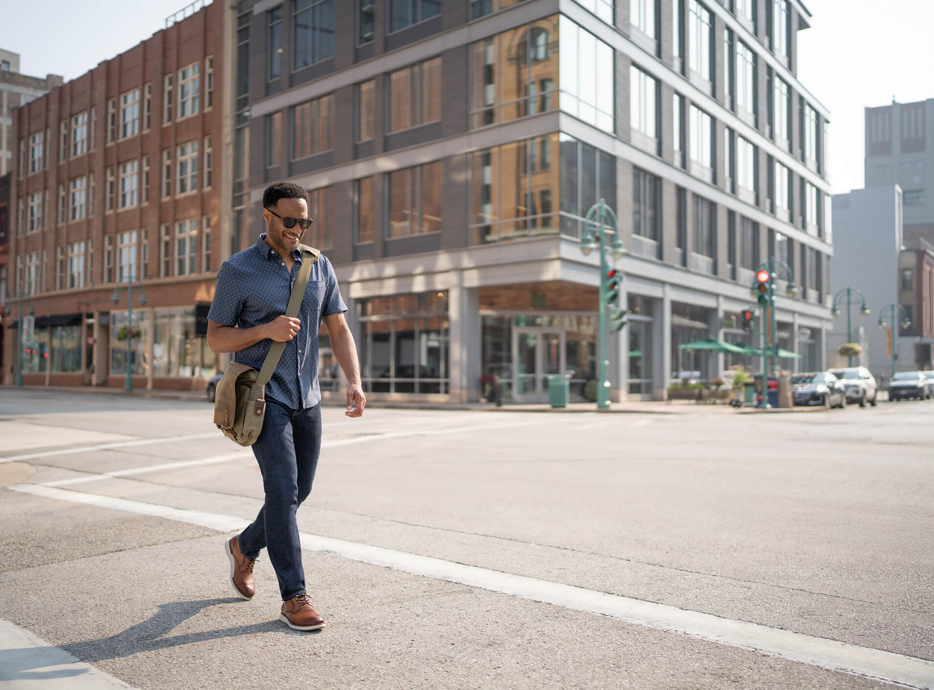 Image features a man walking through the city wearing the Florsheim Norwalk Plain Toe Oxford.