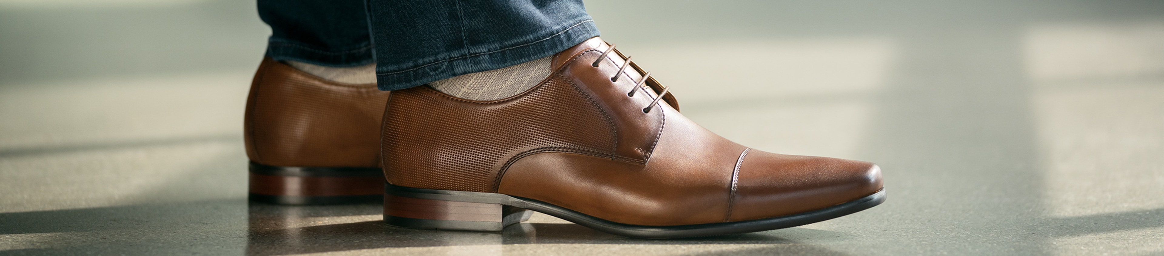 The featured shoe in this image is the Postino Cap Toe Oxford in Cognac.